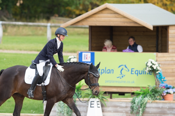 woman patting a horse whilst riding